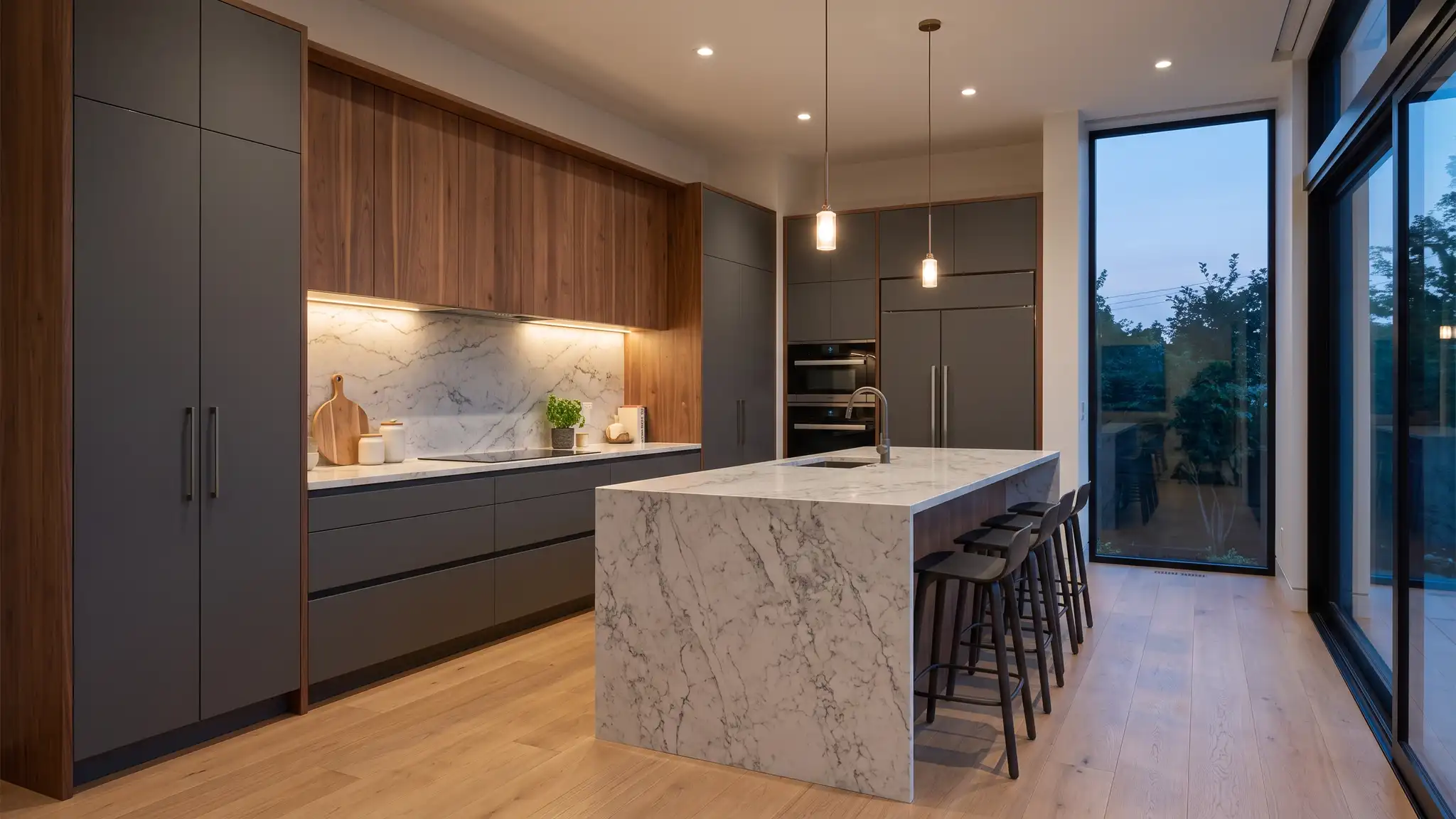 Contemporary | Music City Kitchen Remodeling A sleek contemporary kitchen with flat-panel cabinets, a waterfall quartz island and a full-height stone slab backsplash