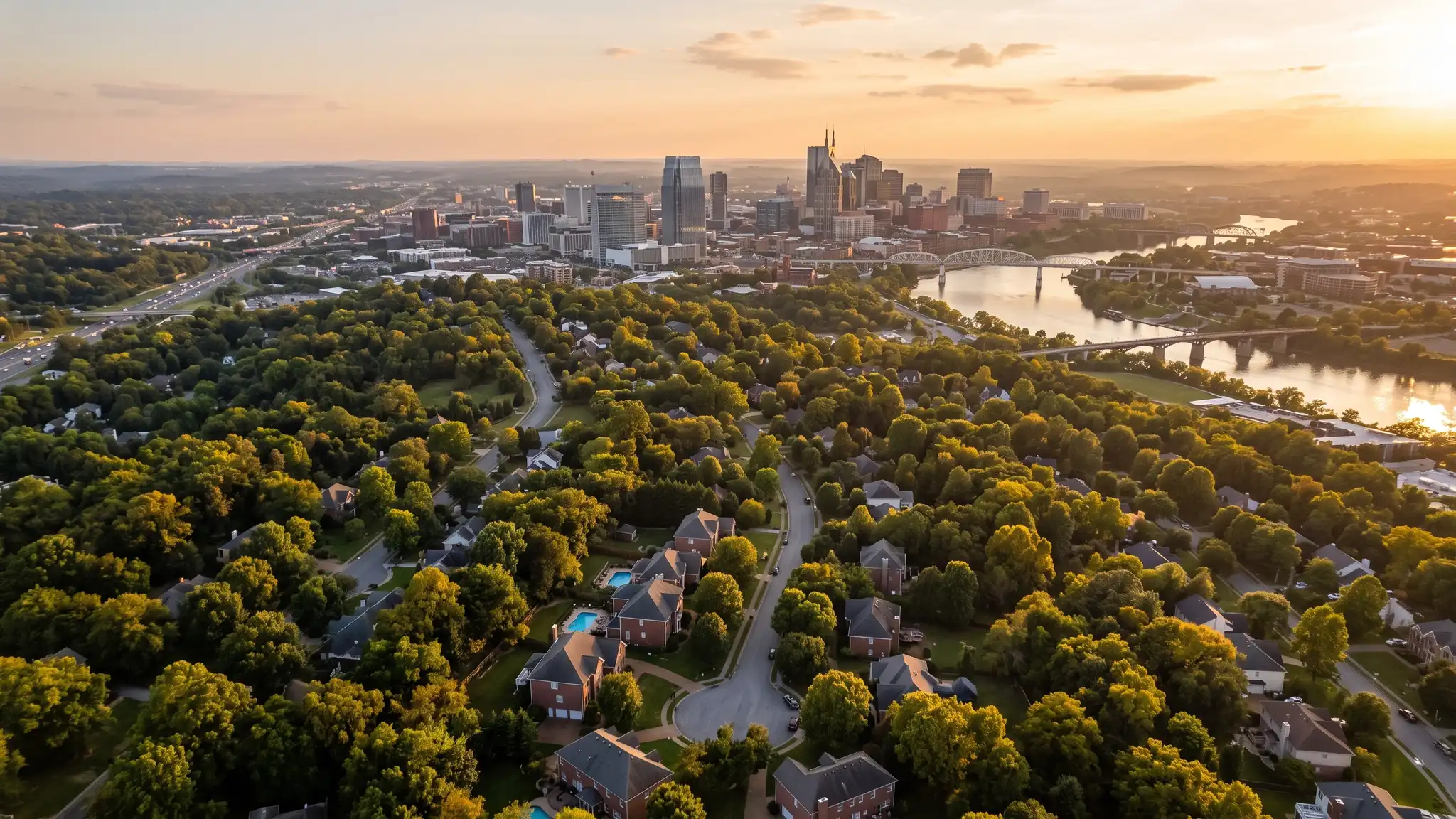 Kitchen remodeling service areas | Nashville and Middle Tennessee Aerial view of the Nashville skyline at golden hour above tree-covered neighborhoods with brick homes and the Cumberland River in the distance